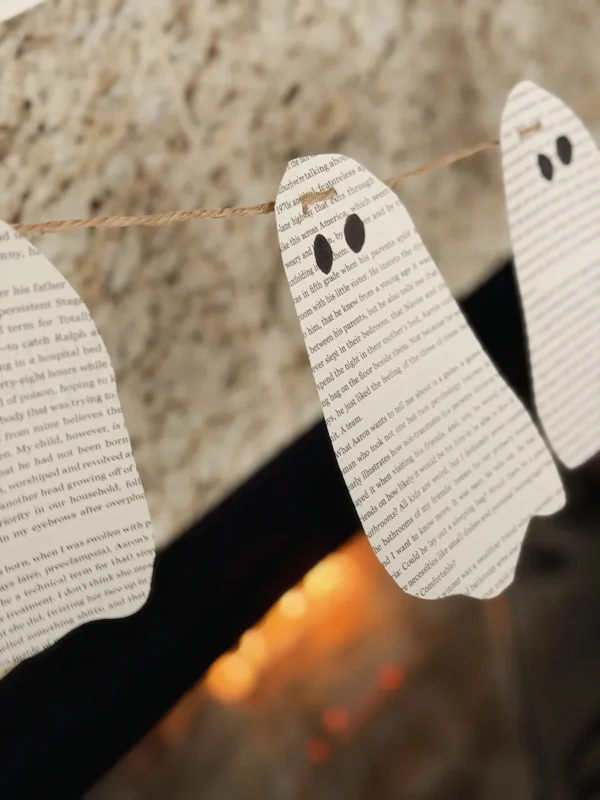 Book page ghost garland hung over the fireplace