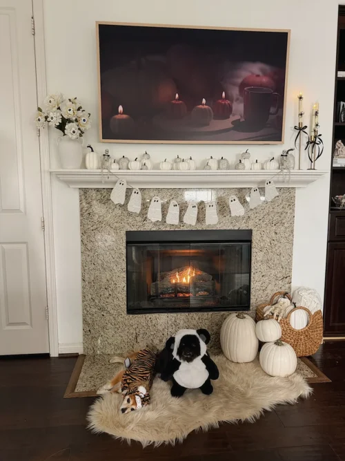 Chic black and white Halloween mantel decor with DIY book page ghost garland and pumpkins