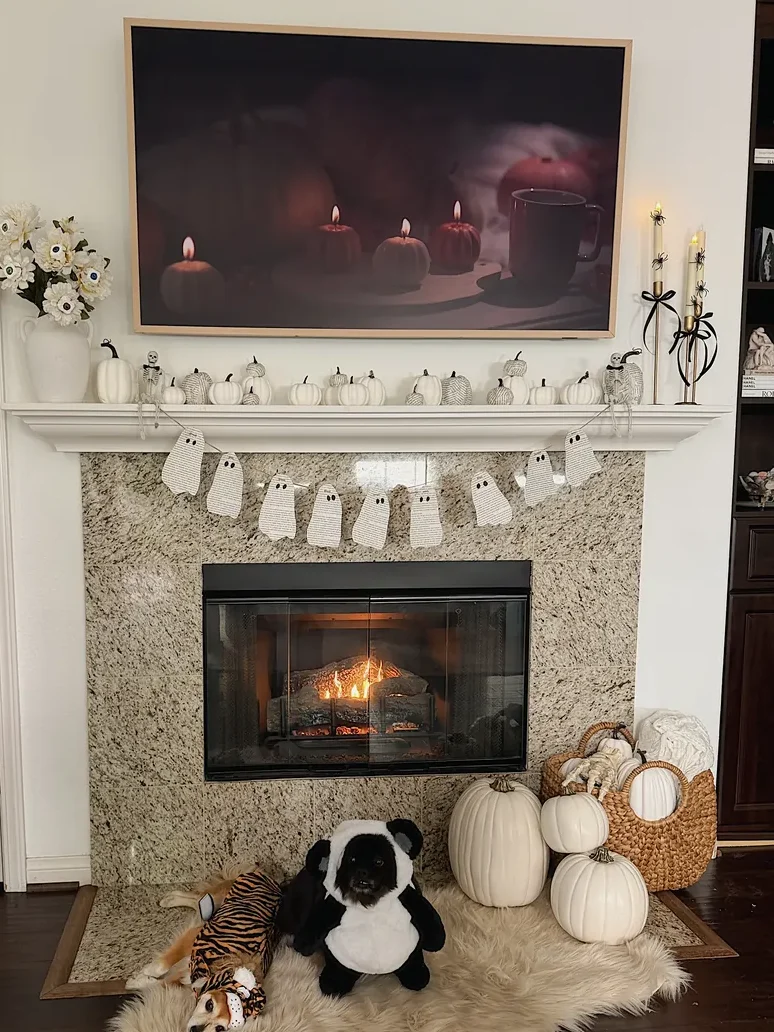 Chic black and white Halloween mantel decor with DIY book page ghost garland and pumpkins