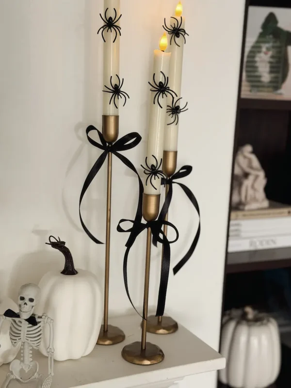 Gold candlesticks with black ribbon and spider rings for Halloween
