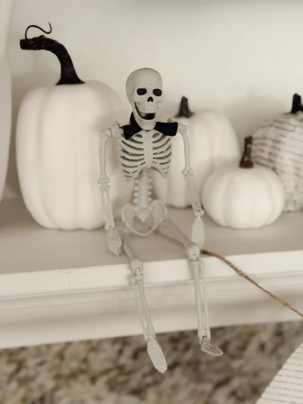 Mini skeleton with black ribbon bow tie on a Halloween mantel