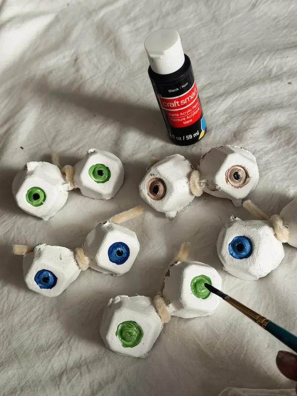 Painting egg carton eyeballs white and green for Halloween decor